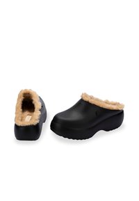 Czarne klapki z miękkim, jasnobrązowym sztucznym futrem w środku. Okrągły czubek, podwyższona podeszwa, teksturowane dno dla lepszej przyczepności, minimalne logo z boku.