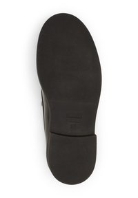 Semelle de chaussure noire avec une surface texturée et un bout arrondi. Présente un petit détail de marque rectangulaire près du talon.