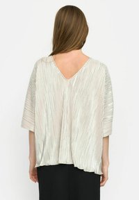 Zilveren geplooide blouse met een V-hals, brede mouwen en een losse pasvorm. De textuur heeft verticale ribbels en een vloeiende silhouet.