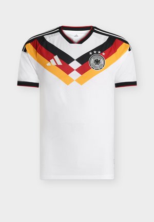 Camiseta de fútbol blanca con patrón de chevrones en negro, rojo y amarillo, logo de la Asociación de Fútbol de Alemania con cuatro estrellas y las rayas de Adidas en los hombros.