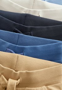 Fünf gefaltete, gerippte Stoff-Taille mit Kordelzügen in Beige, Blau, Dunkelgrau, Navy und Cremefarben, vertikal angeordnet.