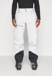 Pantalones de nieve blancos con detalles en negro, dos bolsillos frontales, cremallera lateral y cintura ajustable. Diseñados para deportes de invierno y actividades al aire libre.