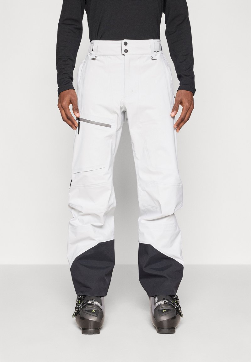 Pantalones de nieve blancos con detalles en negro, dos bolsillos frontales, cremallera lateral y cintura ajustable. Diseñados para deportes de invierno y actividades al aire libre.