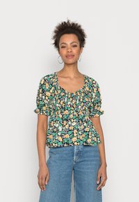 Blusa estampada floral com mangas bufantes, decote quadrado e cintura franzida. Apresenta cores vibrantes sobre um fundo preto. Tecido leve.