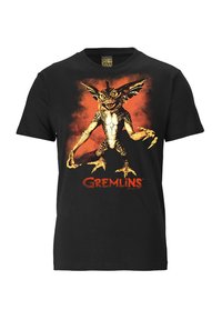Black t-shirt featuring a colorful graphic of a gremlin with yellow accents and orange background, with "Gremlins" text below the design.