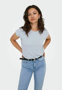 Camiseta de rayas azul claro, de manga corta, combinada con unos vaqueros de tiro alto azul claro y un cinturón negro con hebilla metálica.