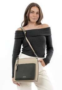Bolso bandolera con un bolsillo frontal de cuero texturizado en gris oscuro sobre un cuerpo beige, con herrajes plateados y una correa ajustable.