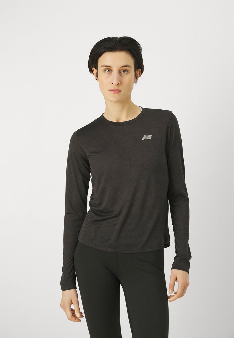 Pitkähihainen musta urheilupaita, jossa on slim fit -malli, pyöreä pääntie ja huomaamaton New Balance -logo, valmistettu hengittävästä, tekstuurista materiaalista.
