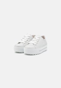 Baskets blanches texturées avec une plateforme épaisse, dotées de bouts ronds, de lacets blancs et de légères nuances de gris sur la semelle.