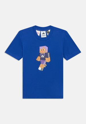 Modré tričko s krátkym rukávom s pixelovým postavičkou z Minecraftu, ktorá má na sebe čierne a fialové oblečenie Adidas, vytlačené na prednej strane.