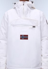 Biały polar z zamkiem błyskawicznym z przodu i haftowaną flagą norweską. Wykonany z gładkiego, wodoodpornego materiału, z kapturem na sznurku.