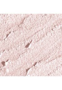 Puder o brzoskwiniowym odcieniu, o drobnej, błyszczącej teksturze. Powierzchnia pokazuje delikatne rowki i iskrzące się wykończenie, odpowiednie do makijażu.