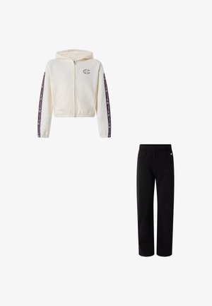 Witte jas met capuchon en rits met zwarte en rode logostrepen op de mouwen, gecombineerd met effen zwarte broek met elastische tailleband.