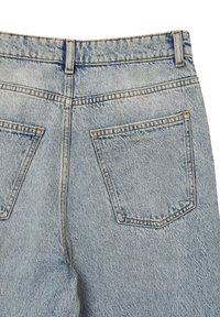 Jeans in denim azzurro chiaro con due tasche posteriori, cuciture visibili e una texture leggermente sbiadita. La vita è dotata di passanti per la cintura.
