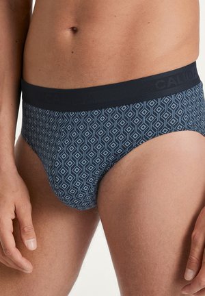 Himbeerblaue Unterhose mit einem geometrischen Rautenmuster in Hellblau, ausgestattet mit einem kontrastierenden schwarzen Elastikbund, der mit "CALVIN" geprägt ist.