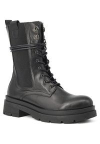 Stivale alla caviglia in pelle nera con suola in gomma spessa, allacciatura frontale, pannello laterale elastico e dettagli in metallo. Presenta una linguetta per una facile calzata.