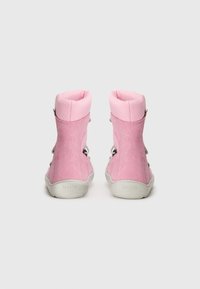 Roze suède hoge laarzen met geribde stoffen manchet, zilveren oogjes en witte rubberen zolen. Achteraanzicht dat het gestructureerde materiaal benadrukt.