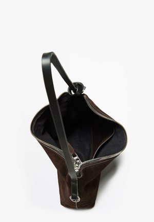 Bruine suède handtas met een zwarte leren schouderband en ritssluiting, met een ruime binnenkant en een gestructureerd, taps toelopend ontwerp.