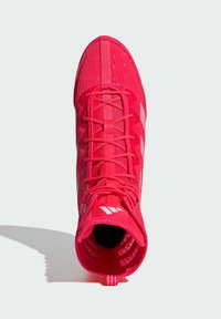 Scarpa sportiva rossa con upper in mesh testurizzato, chiusura con lacci e suola piatta. Presenta strisce bianche come accento e una linguetta sul retro.