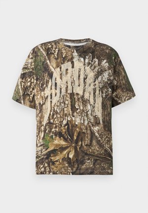 T-shirt κοντού μανικιού με ρεαλιστικό καμουφλάζ φλοιού δέντρων και φύλλων και μεγάλη ξεθωριασμένη λευκή γραφή στο στήθος.
