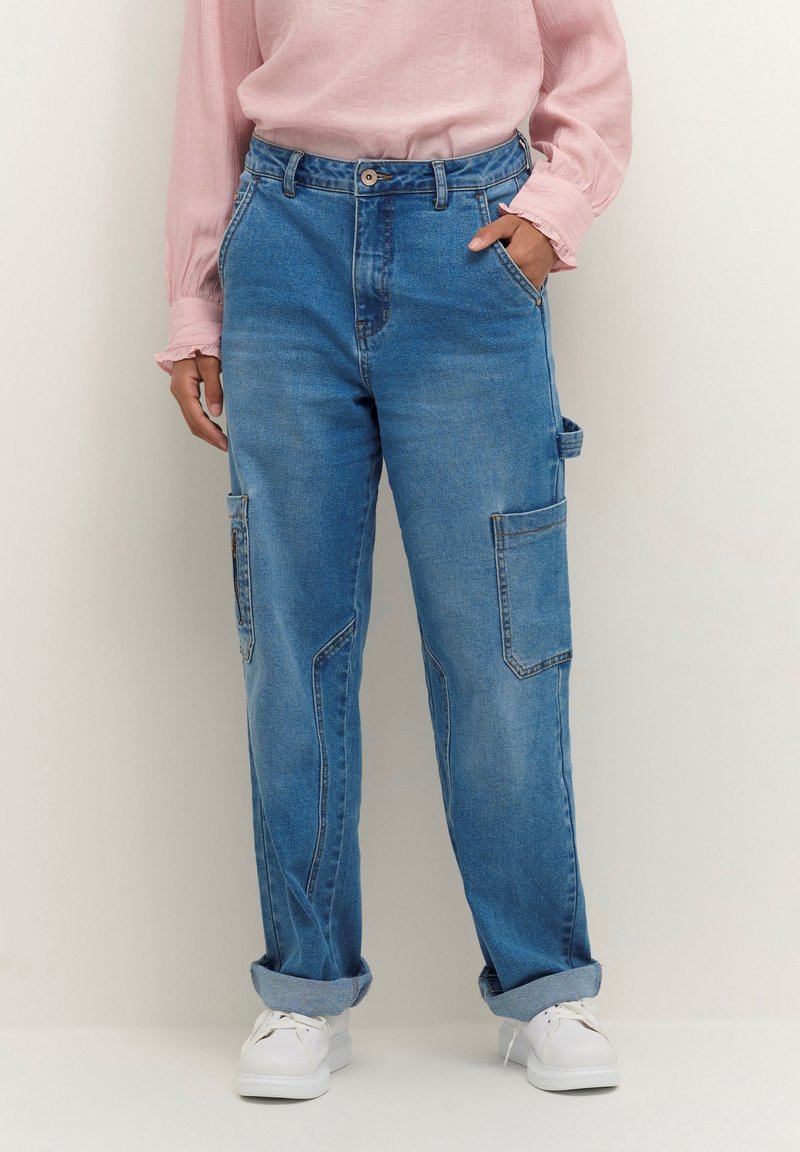 Blå denim cargobyxor med avslappnad passform, med sidofickor, uppvikta fållar och knäppning, i kombination med en ljusrosa topp.