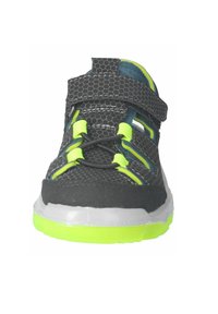 Černá síťovaná sportovní obuv s neonově zelenými akcenty, nastavitelnými popruhy a texturovaným povrchem. Má polstrovanou podešev a živé detaily.
