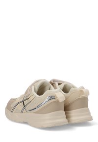 Zapatillas deportivas beige con franjas laterales negras y grises, de tejido de malla y con tiradores en los talones, mostradas desde un ángulo trasero.