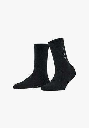 Chaussettes noires en tissu doux, avec une bordure côtelée et un détail de logo au niveau de la cheville. Texture lisse, longueur mi-mollet.