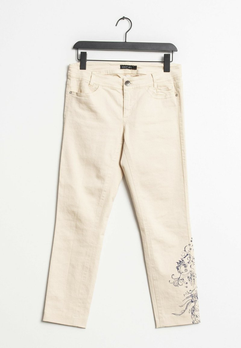 Vaqueros de mezclilla beige con un diseño ajustado, que presentan un patrón floral en azul en la pierna izquierda y un estilo de cinco bolsillos.