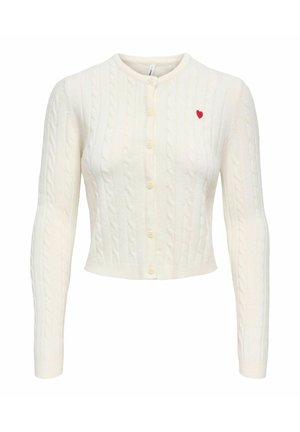 Cardigan court blanc en maille torsadée avec manches longues, encolure ronde, boutonné à l'avant, et petit cœur rouge brodé sur le côté gauche de la poitrine.