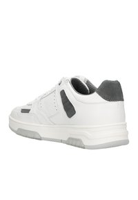 Sneaker atletica bianca con accenti in suede grigio, tomaia in pelle, linguetta in rete e suola in gomma. Caratterizzata da un collare imbottito e rivestimenti testurizzati.