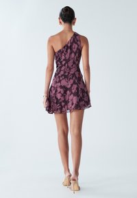 Fialové kvetinové šaty s jednoramenným dizajnom, krátkou dĺžkou a ľahkou látkou, s voľným lemom a vrstvenou textúrou.