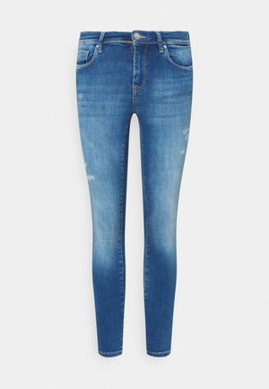 Tynne blå jeans laget av denim, med et falmet design og lett slitasje, fem-roms styling og metallknapp-lukkning.
