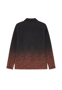 Fekete dzseki, amelynek színátmenete van, szilárd feketéből narancsos, pöttyös mintába megy át. Gallérral és gombos mandzsettákkal rendelkezik.