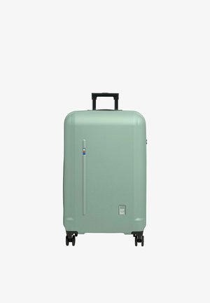 Maleta rígida en verde menta mate, cuenta con un asa retráctil negra, cuatro ruedas negras y un logo sutil en la base.
