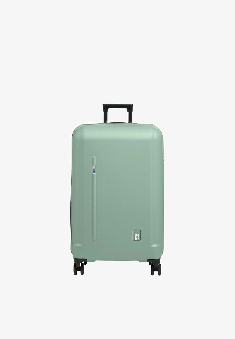 Valigia rigida di colore verde menta opaco, dotata di manico nero retrattile, quattro ruote nere e un logo discreto sulla base.