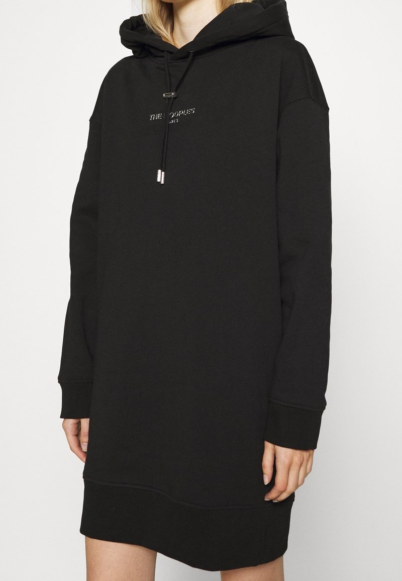 Robe à capuche noire en tissu doux, dotée d'une capuche avec cordon de serrage, de manches longues et d'une coupe décontractée. Détail de logo subtil à l'avant.