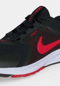 Μαύρο και κόκκινο αθλητικό παπούτσι Nike Star Runner 5 με κόκκινο λογότυπο Swoosh, κείμενο "Dynamic Fit" και λευκές και κόκκινες λεπτομέρειες στη σόλα.