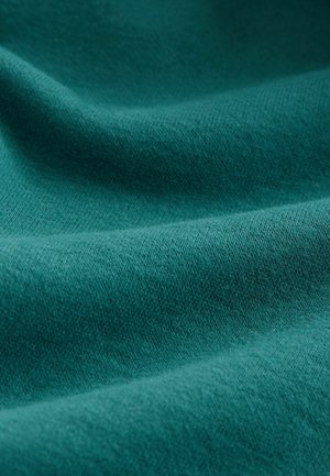 Textured fabric in deep teal; soft and slightly fuzzy surface with a subtle weave pattern, showcasing rich color and uniform texture.