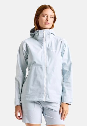Veste imperméable bleu clair avec une fermeture éclair devant, une capuche ajustable et des poches. Texture lisse, design minimaliste avec un détail de logo.