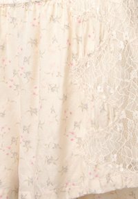 Lightweight, cream fabric featuring a floral pattern in grey and pink, complemented by intricate lace detailing on one side.