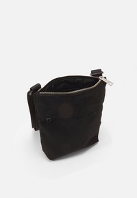 Černá textilní taška se zipem na vrchu, nastavitelným popruhem a hladkým povrchem. Má minimalistický design a jednu vnější kapsu.