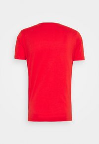 Camiseta de algodón roja con cuello redondo, mangas cortas y una textura suave. Diseño de espalda sin costuras, sin etiquetas ni patrones visibles.