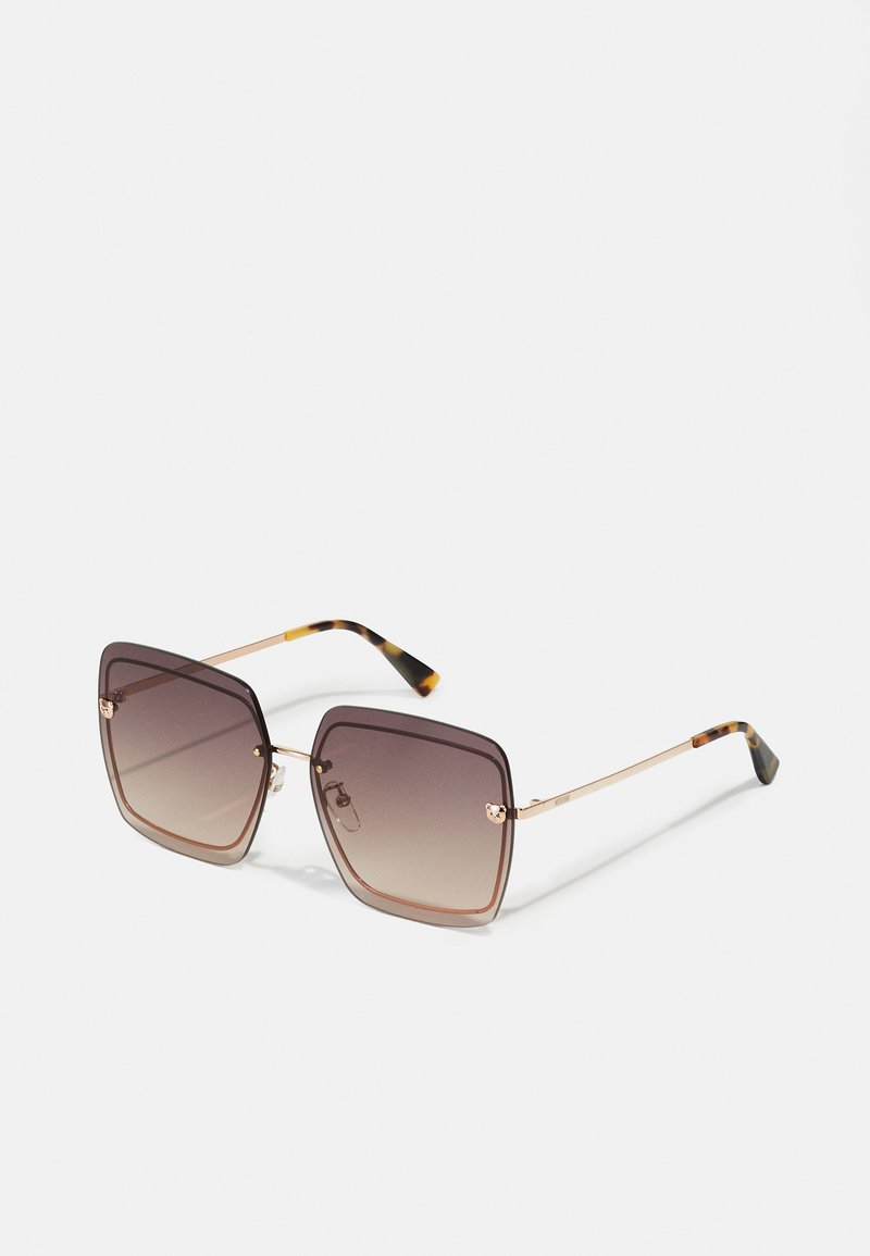Lunettes de soleil carrées avec des verres dégradés bruns, monture en métal doré et embouts de branches en motif écaille.