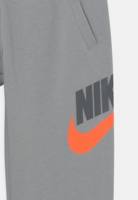 Nike Sportswear CLUB PANT UNISEX - Träningsbyxor - light smoke grey/pink foam/white