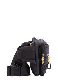 Borsa in nylon nera a vita con doppi scomparti con zip, tracolla regolabile e tirazip gialli. Presenta una superficie testurizzata e un design compatto.