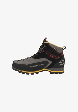 Czarno-szare buty trekkingowe z zamszową i syntetyczną cholewką, żółtymi akcentami, wytrzymałą gumową podeszwą oraz metalowymi oczkami na sznurówki.