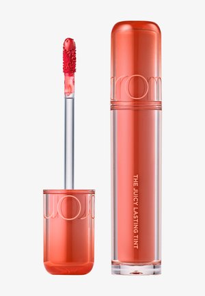 Behälter und Applikatorstab für Lippenfarbe in Korallrosa, beschriftet mit "The Juicy Lasting Tint" auf durchsichtiger zylindrischer Verpackung.