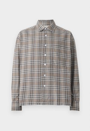 Chemise à carreaux marron avec des lignes blanches et marron foncé, dotée d'un col et d'une poche poitrine unique, fabriquée en tissu léger.