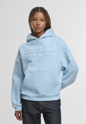 helehelesinine kapuutsiga pusa, valmistatud pehmest kangast, esiosas tasku ja kontrastse varjundiga reljeefne logo. Lõdvestunud lõige.